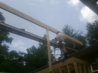 Carpenter setting a ridge beam over a new addition frame — Ice Dam Removal by Roofing Brothers in Tecumseh